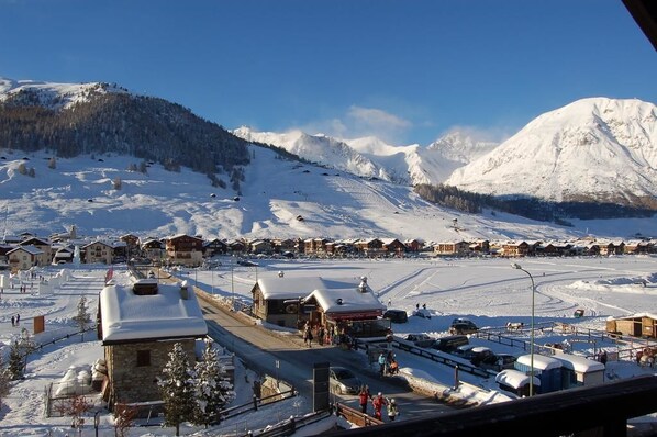 A snow-covered mountain town with buildings and a ski slope.