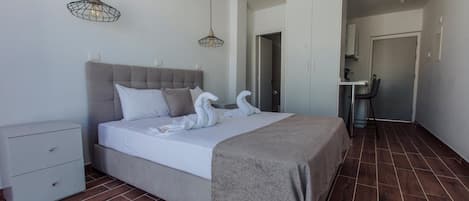 A modern bedroom with a large bed, a bedside table, and a wardrobe.