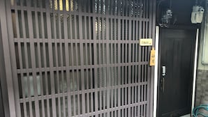 A metal gate with a sign reading "Uzukki". - Kyoto Machiya UZUKI (Kyoto)