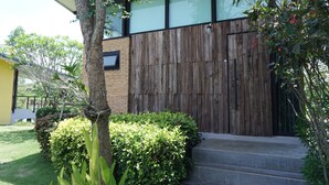A modern building with a wooden fence, steps leading to a door, and a well-maintained garden. - The Lampang Villa (Lampang)