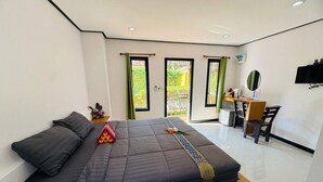 A bedroom with a bed, a desk, and a chair. - Kanyaphat Gardenview Resort (Ban Dung)