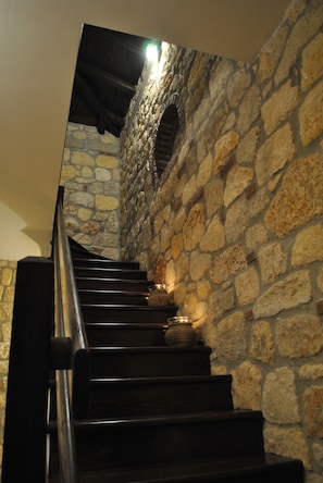 Eine Treppe mit Steinwänden und Holzstufen.