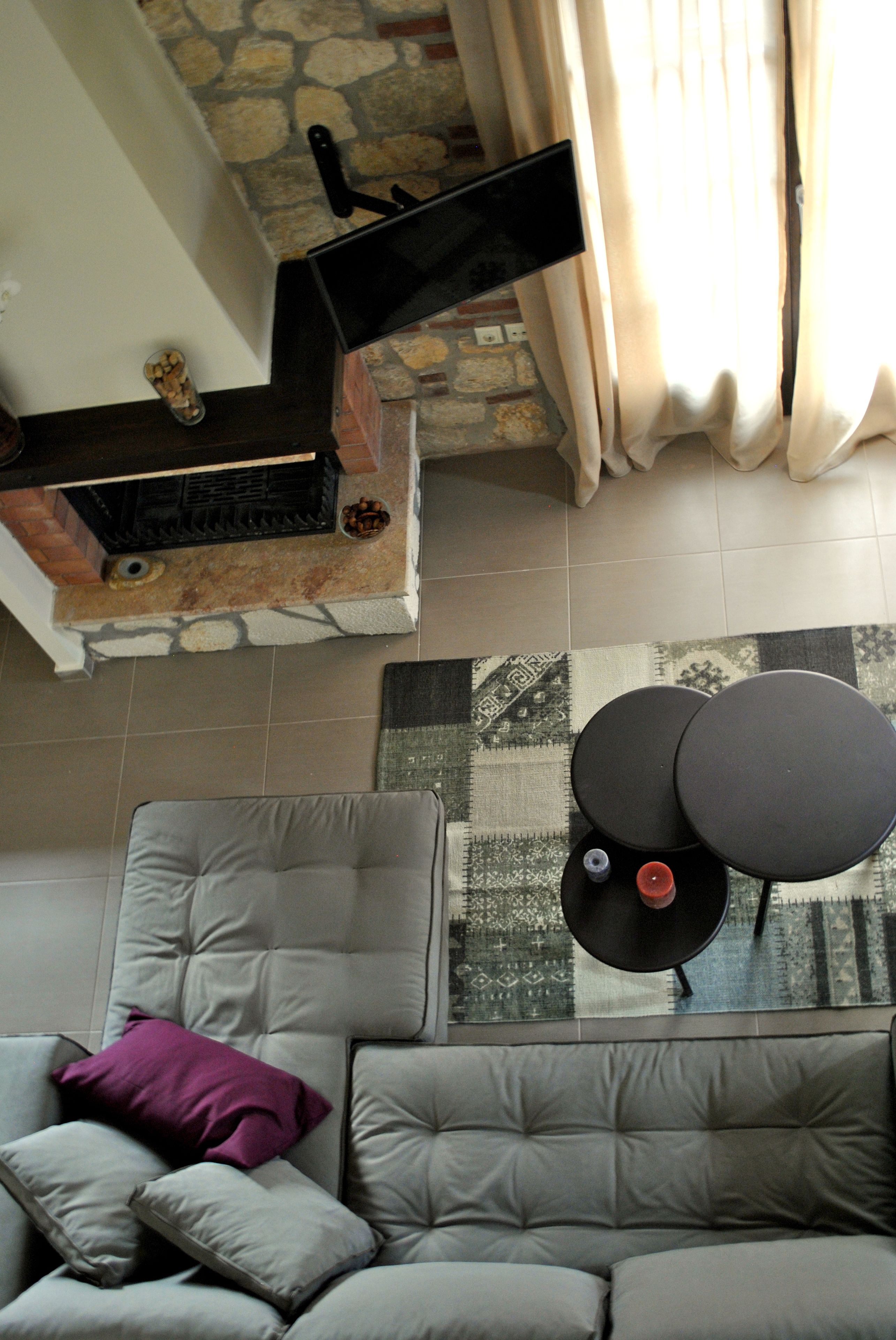 A living room with a sofa, a small round table, and a fireplace.