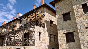 A stone building with multiple windows and a wooden balcony structure.