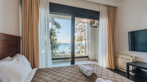 A hotel room with a bed, a TV, and a view of the sea. - Apartments Kuce Lekovica snack bar- Bistro & Beach  (Bar)
