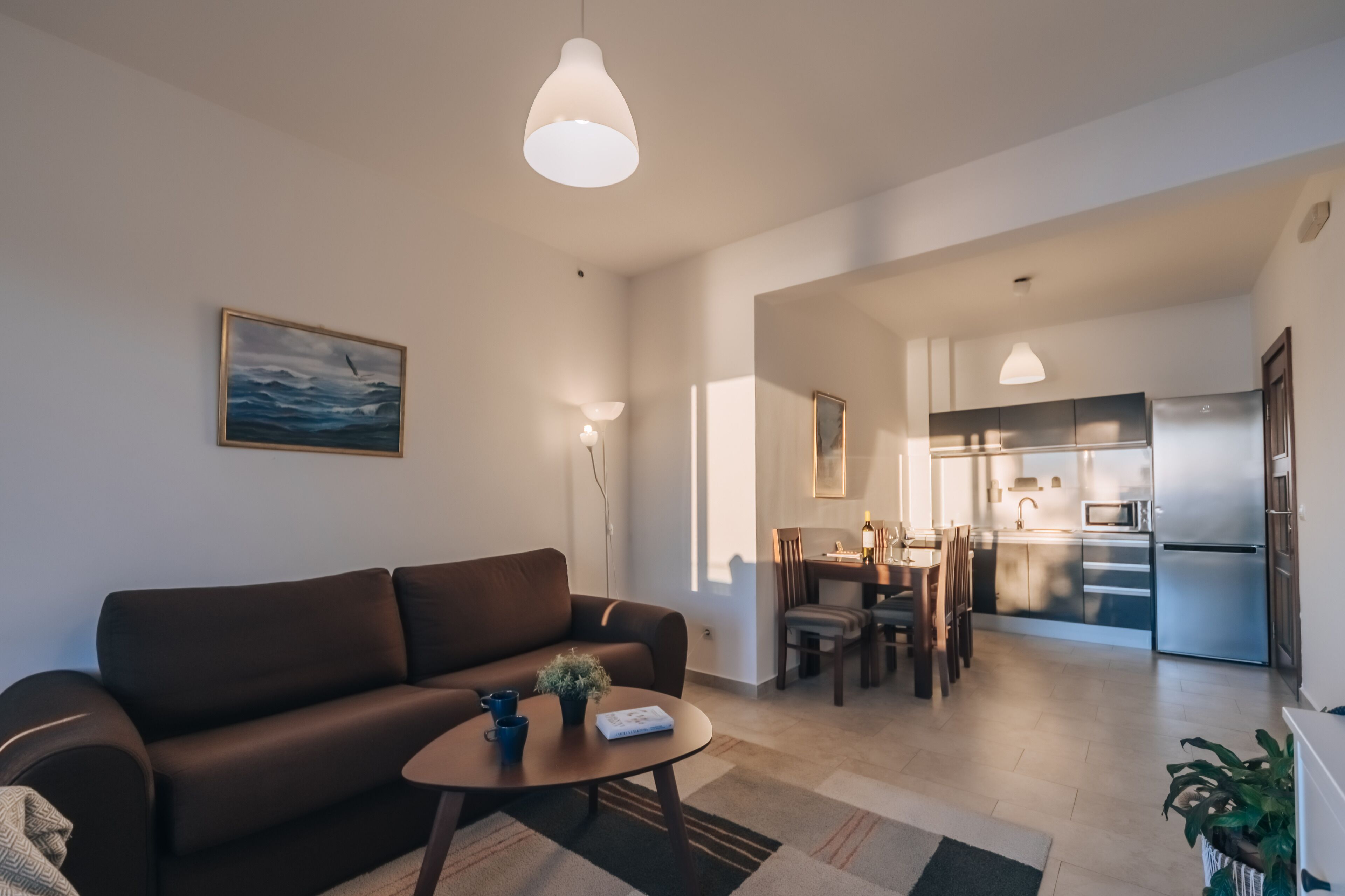 Ein modernes Wohnzimmer mit Sofa, Couchtisch und einem Gemälde an der Wand.