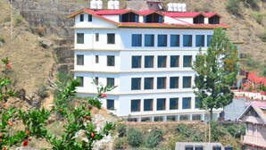 A multi-story building with a red roof, white walls, and multiple windows. - Jade Vine Resort (Shimla)