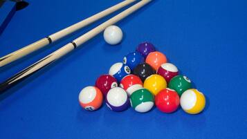 A pool table with a blue felt surface and a triangular arrangement of billiard balls.
