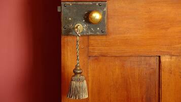Une porte en bois avec une poignée de porte en laiton et un porte-clés en laiton orné d’une frange.