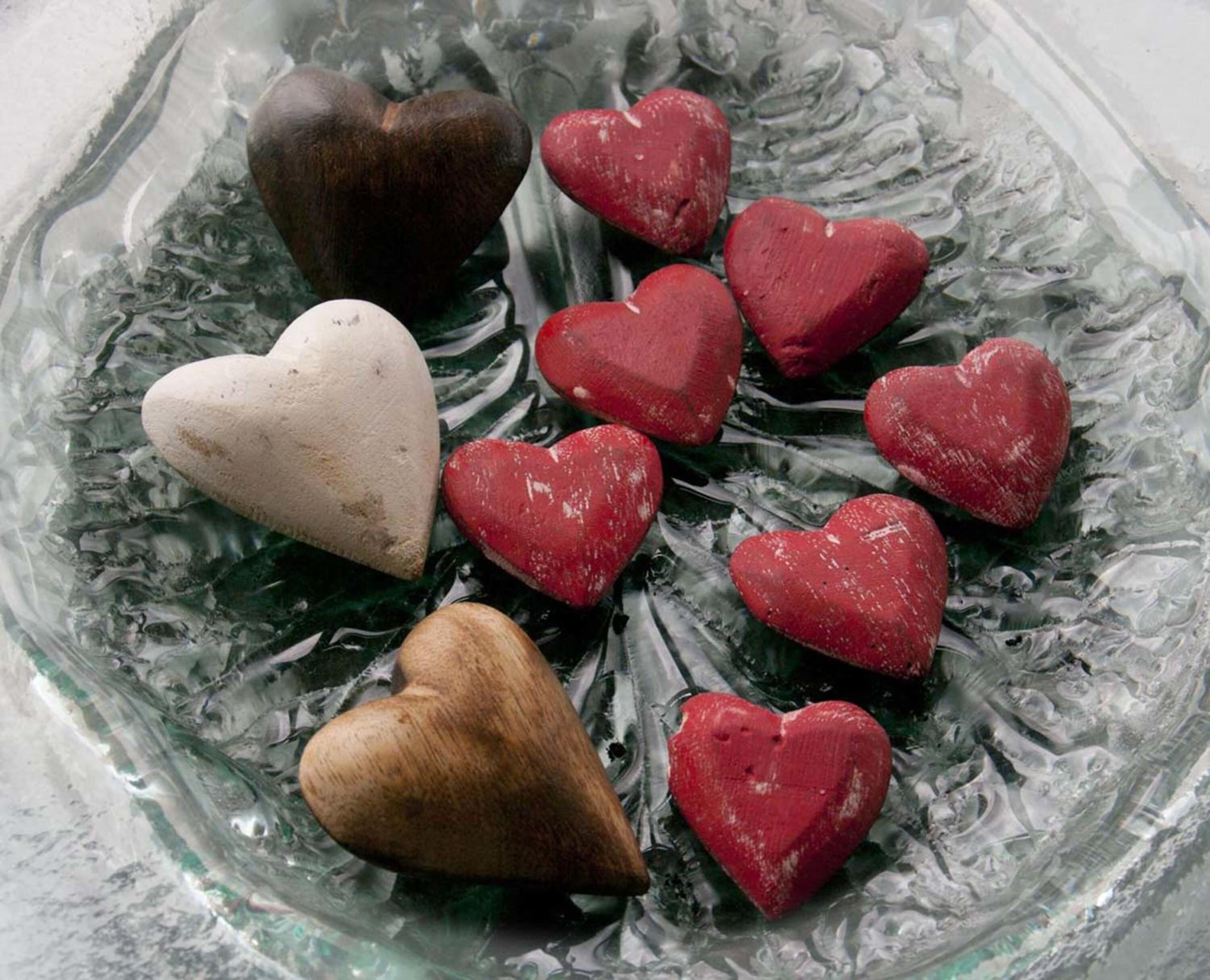 Un cuenco de vidrio con objetos en forma de corazón.