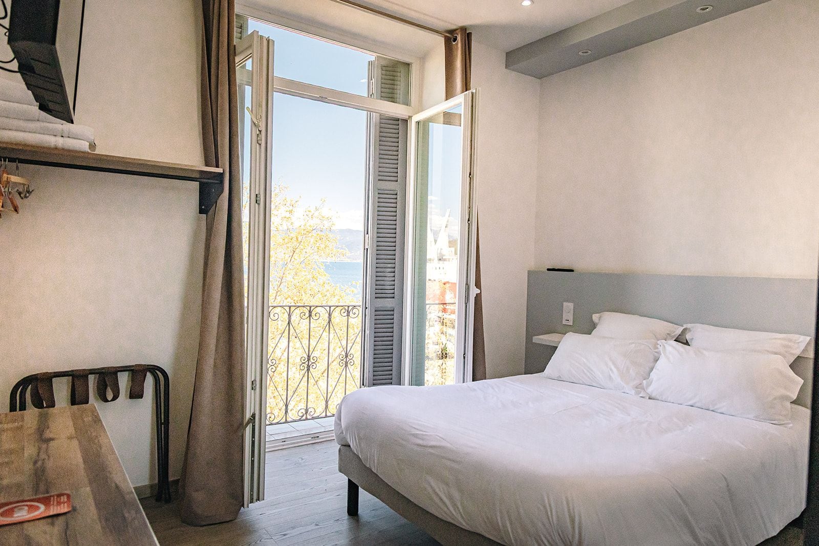 Habitació d'hotel amb un llit, escriptori i un balcó amb vistes.