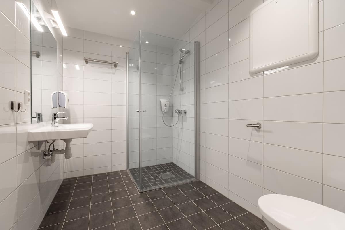 Habitación junior | Baño | Ducha, secador de pelo y toallas