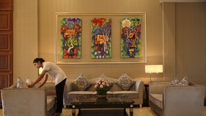 Um saguão com um conjunto de sofás, uma mesa de centro e um quadro na parede.