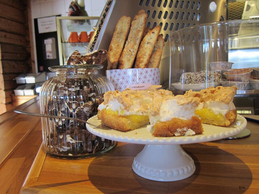 A dessert display with éclairs, a jar of chocolate, and breadsticks.
