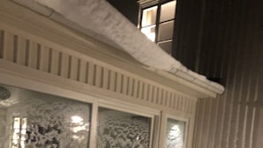 A building with snow-covered windows and a snow-covered ground.