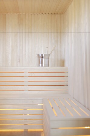 A sauna with wooden benches and a metal bucket. - Tössestugan Herrgårdshotell (Tösse)