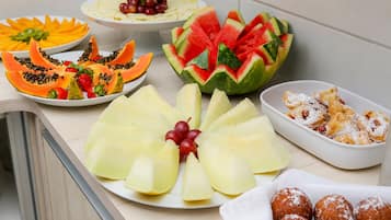 Una variedad de frutas y pasteles sobre una mesa.