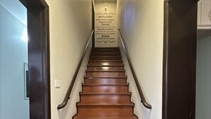 A wooden staircase with a handrail, leading to a landing with a sign. - Pousada Casarão Schmidt (Pomerode)