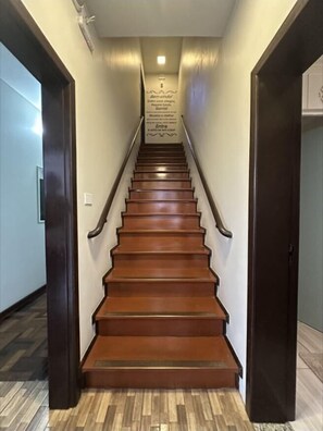 Una escalera de madera con barandilla que lleva a una plataforma con un letrero.