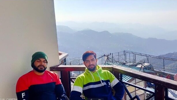 Two individuals on a balcony with a mountain view. - Sun N Star (Dehradun)