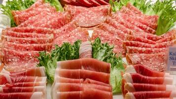Una variedad de carnes y verduras cortadas en un plato.