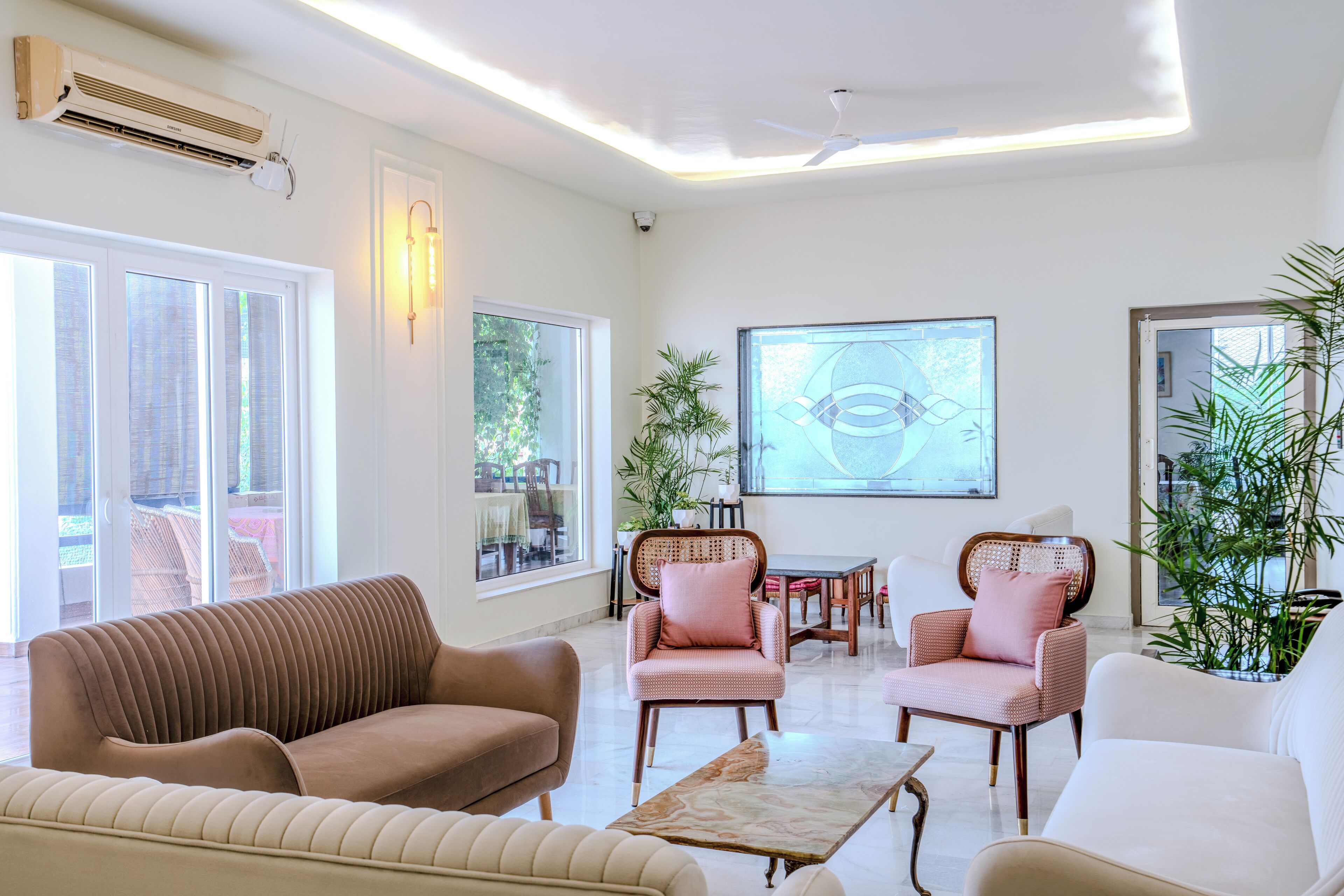 A modern living room with a sofa, armchairs, a coffee table, and a dining area.