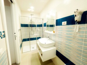 Vierpersoonskamer, uitzicht op zee | Badkamer | Een douche, een haardroger, een bidet, handdoeken