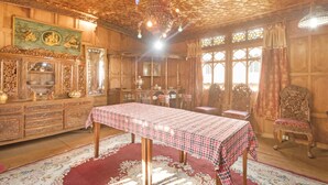 A room with a checkered table, wooden furniture, and a patterned carpet. - GuestHouser 3 BHK Houseboat d520 (Srinagar)