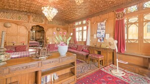 A traditional room with intricate wooden paneling, a chandelier, a sofa set, and a fan. - GuestHouser 3 BHK Houseboat d520 (Srinagar)