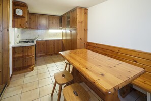 Eine Küche mit Holdekor, einem Holztisch und zwei Barhocker.