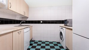 A compact kitchen with a dishwasher, washing machine, and a microwave. - Gonzalo's Guest Apartments - Downtown Historic Flats I (Lisbon)