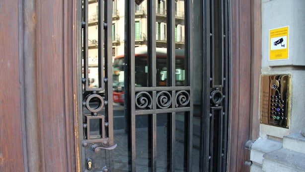 A metal gate with a keyhole and a sign indicating surveillance. - Alternative Creative Youth Hostel Barcelona (Barcelona)