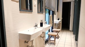 A bathroom with two sinks, a mirror, and a small wooden stool. - Alternative Creative Youth Hostel Barcelona (Barcelona)