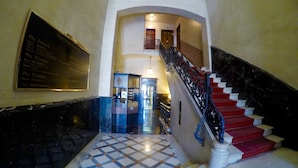 A grand staircase with red steps and a black railing, leading to an upper floor. - Alternative Creative Youth Hostel Barcelona (Barcelona)
