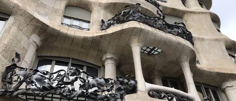 A building with a unique architectural style featuring curved balconies and intricate metal sculptures.