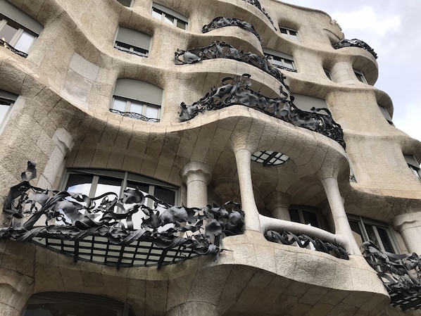 A building with a unique architectural style featuring curved balconies and intricate metal sculptures.