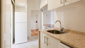 A modern kitchen with white cabinets, a built-in sink, and a Bosch refrigerator. - Gonzalo's Guest Apartments - Downtown Historic Flats III (Lisbon)