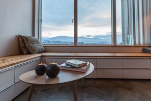 A cozy seating area with a view of snow-covered mountains through large windows. - Villa Lola (Akureyri)