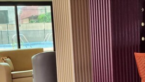 A modern lobby with a sofa, a pillar, and a chair. - Golden Hôtel (Abidjan)