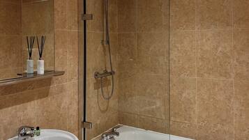 A bathroom with a bathtub, a sink, and a shower.