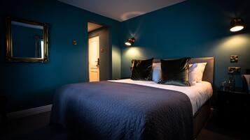 A bedroom with a large bed, a mirror, and bedside lamps.