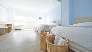 Une chambre d’hôtel moderne avec deux lits, un bureau et des paniers en osier.