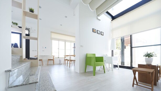 Un espace de vie spacieux et moderne, comprenant un escalier, une table à manger et des chaises.