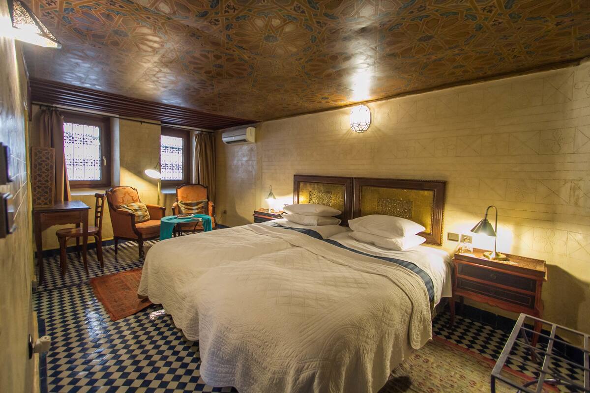 Una habitación de hotel con una cama grande, un escritorio, una silla y una mesita.