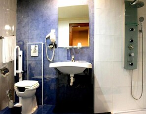 Ein Badezimmer mit Toilette, Waschbecken, Spiegel und Dusche.