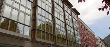 Un edificio de varios pisos con amplias ventanas y fachada roja.