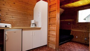 Eine kleine Küche mit Kühlschrank, Kaffeemaschine und Waschmaschine.