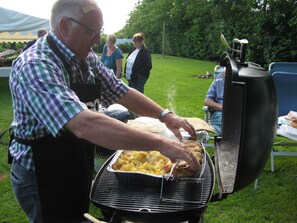 En mand griller mad udendørs.