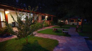 A well-lit outdoor area with a stone pathway leading to a building with a covered porch. - B&B Donna Maja (Centola)