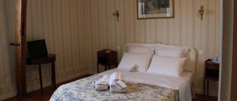 A neatly arranged bedroom with a bed, a small table, and a chair.